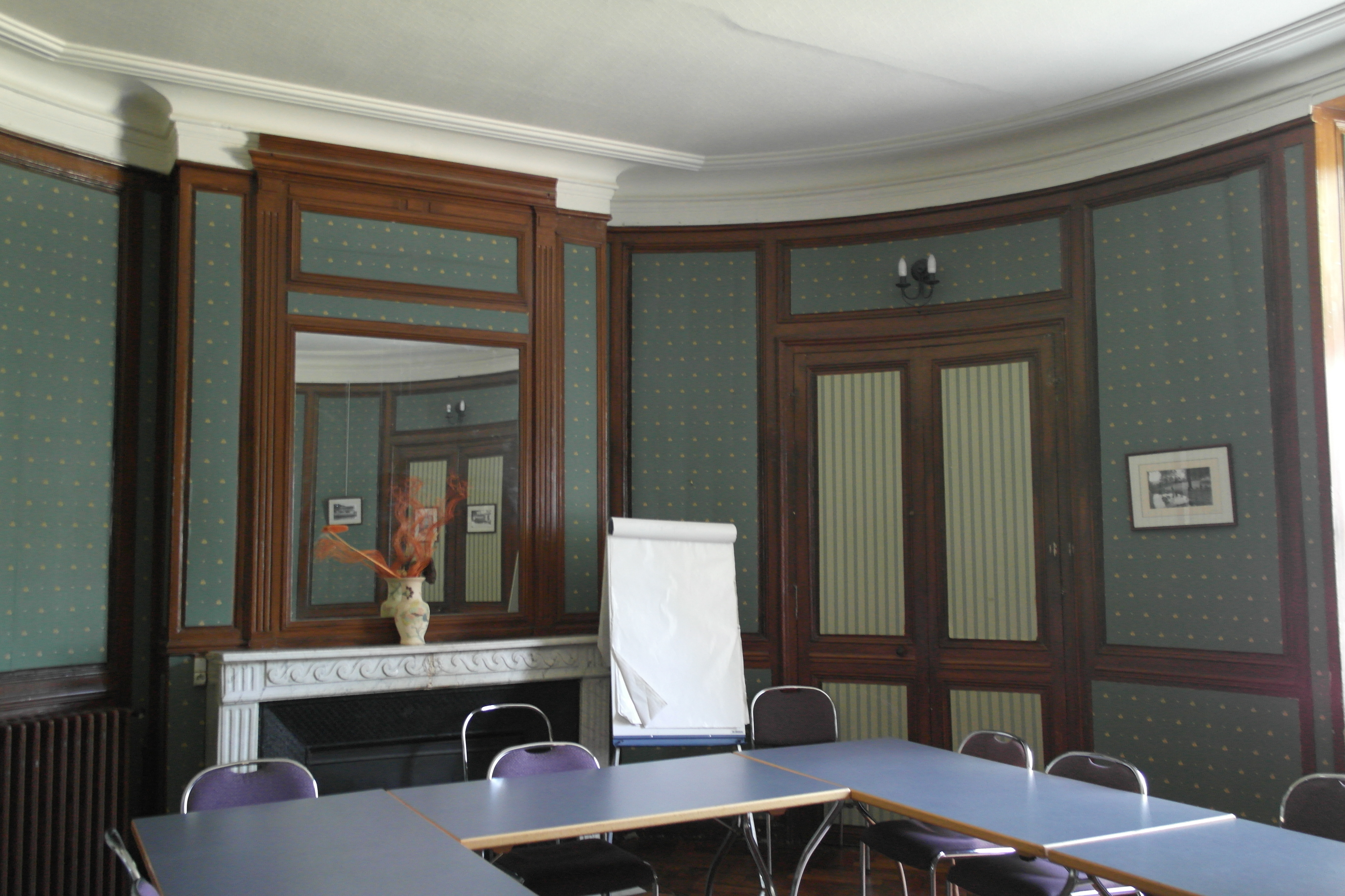 A view of an interior room of the chateau with curved walls and a fireplace.